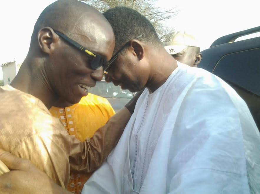 Pape Dieng en boubou traditonnel marron souhaitant la bienvenue à son ami Daouda Dia à son arrivée